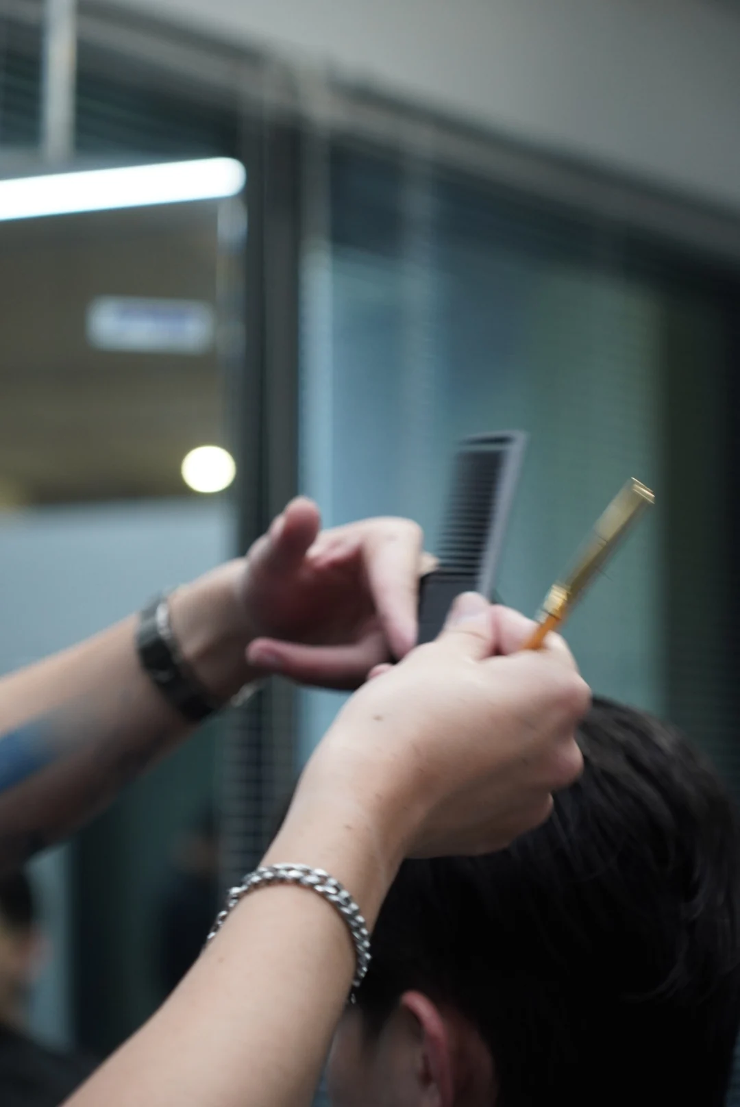 A comb lifting a section of hair for scissors