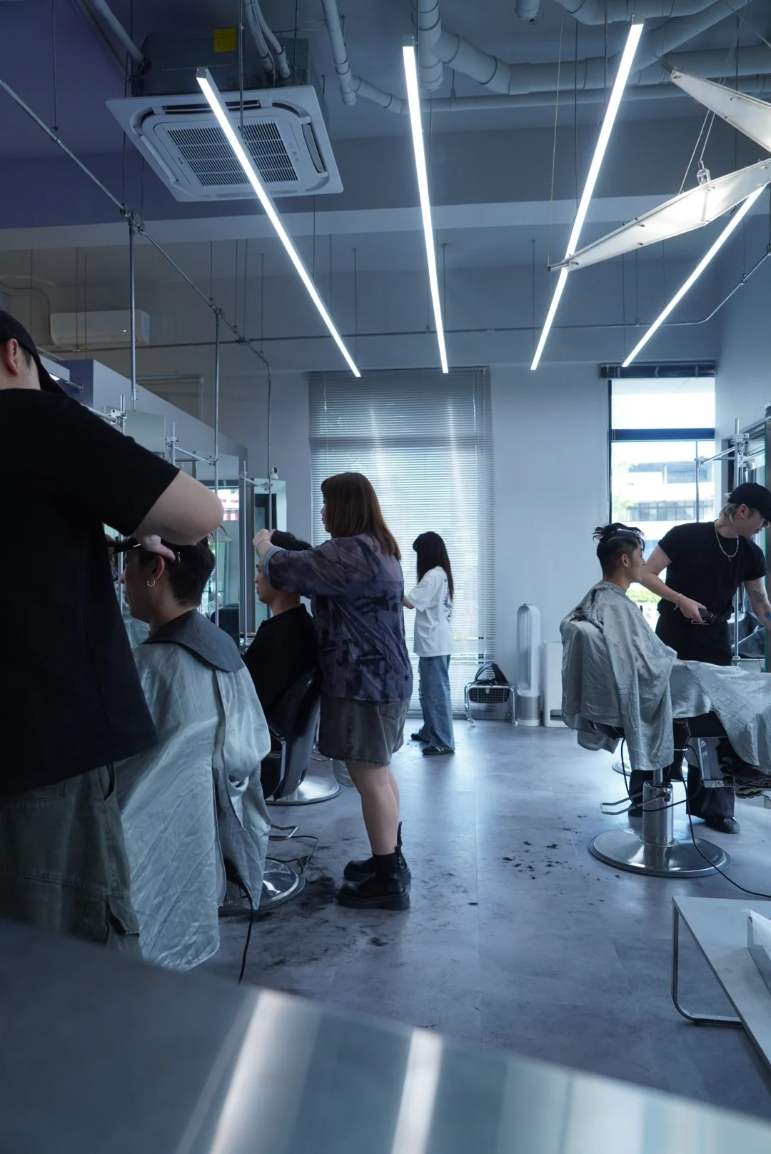 A view along the salon aisle toward occupied chairs