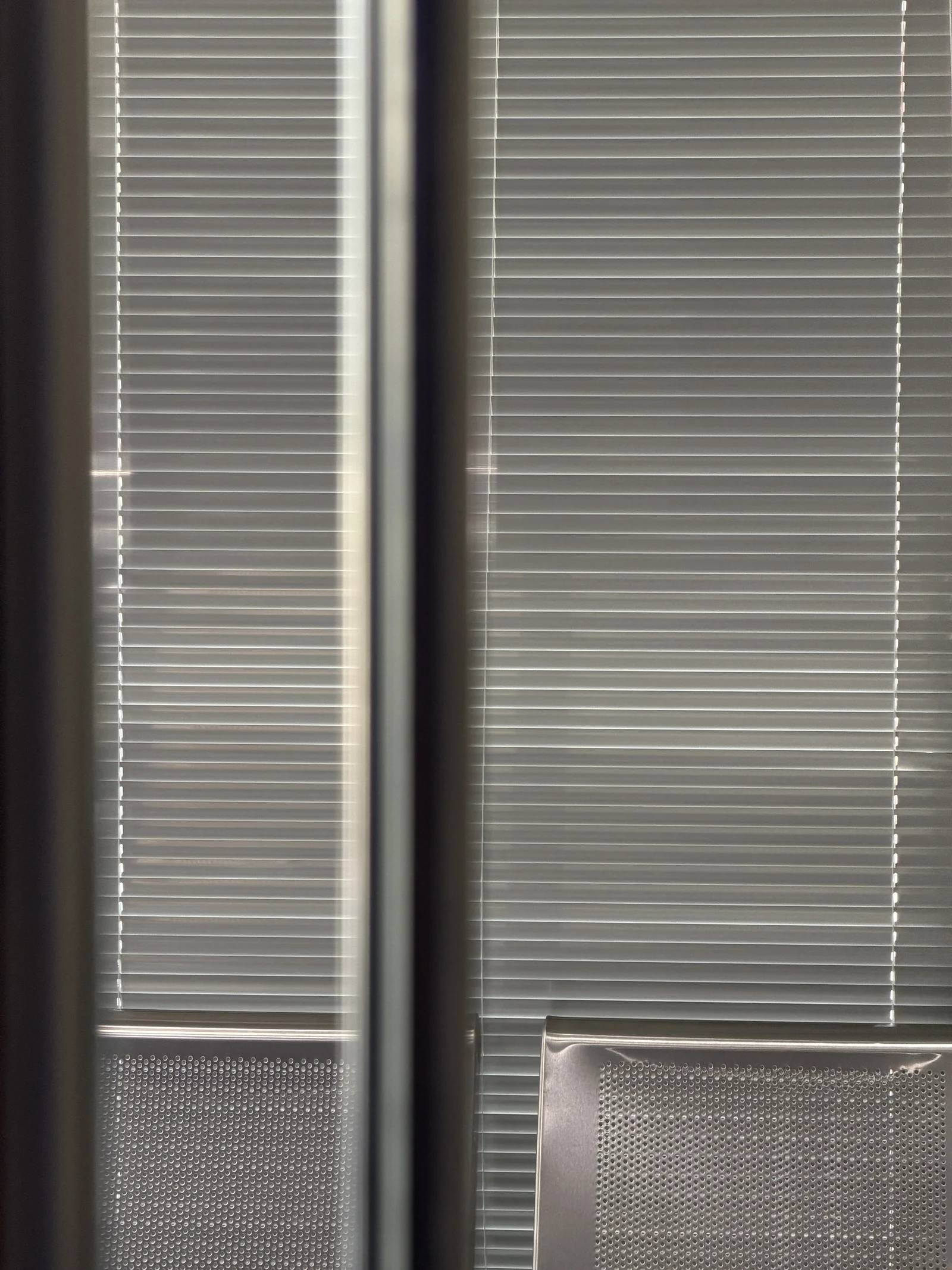 A work chair and daylight in front of window blinds